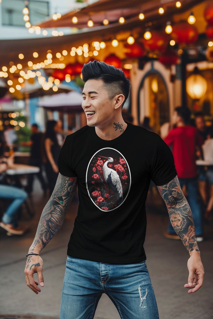 young tattooed man wearing a black graphic t-shirt featuring a Crane with cherry blossom trees print
