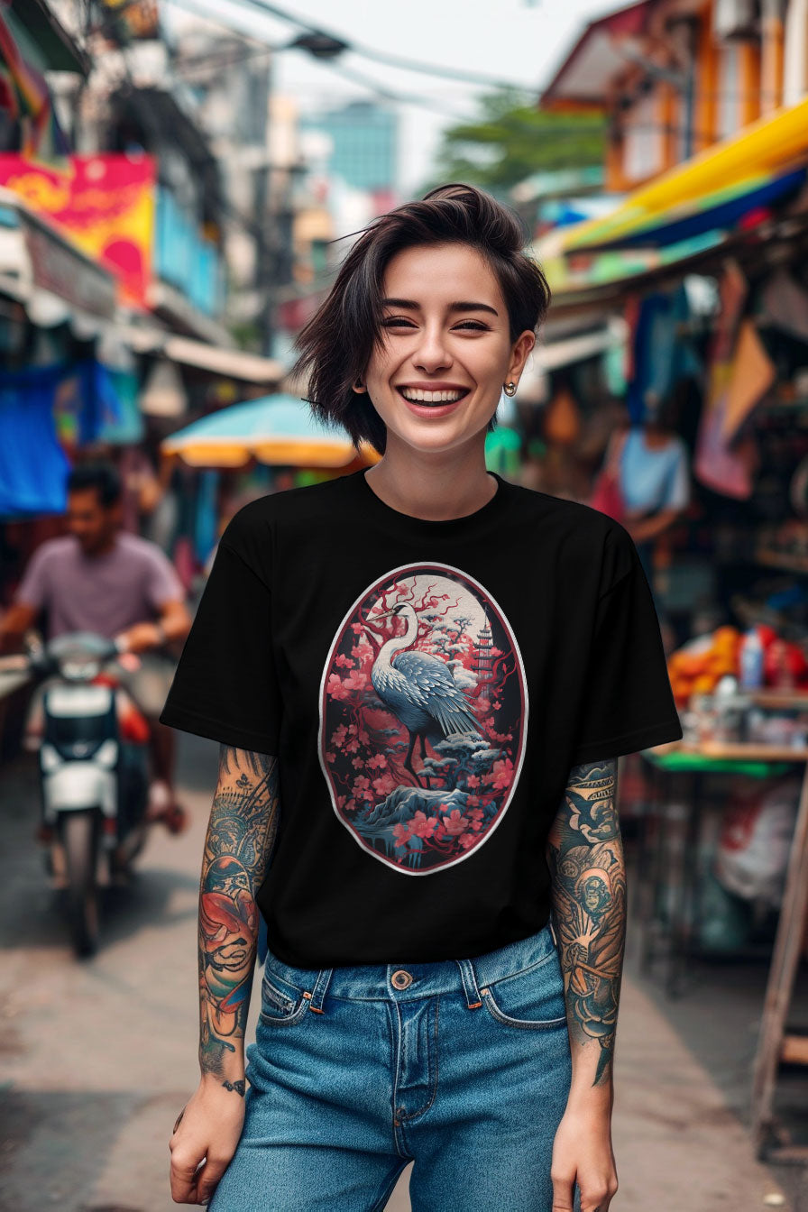 young tattooed woman wearing a black graphic t-shirt featuring a Crane with cherry blossom trees print