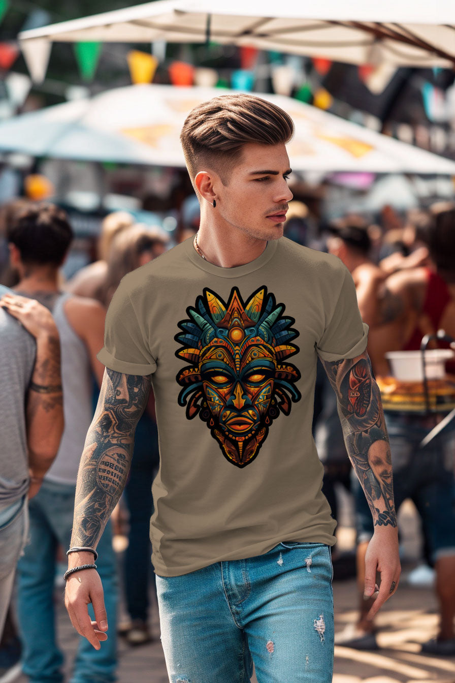 young tattooed man wearing a sand colored graphic t-shirt featuring a Aztec mask print