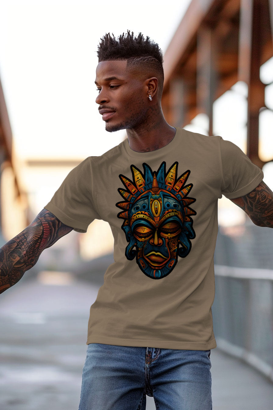 young tattooed man wearing a sand colored graphic t-shirt featuring a Aztec mask print