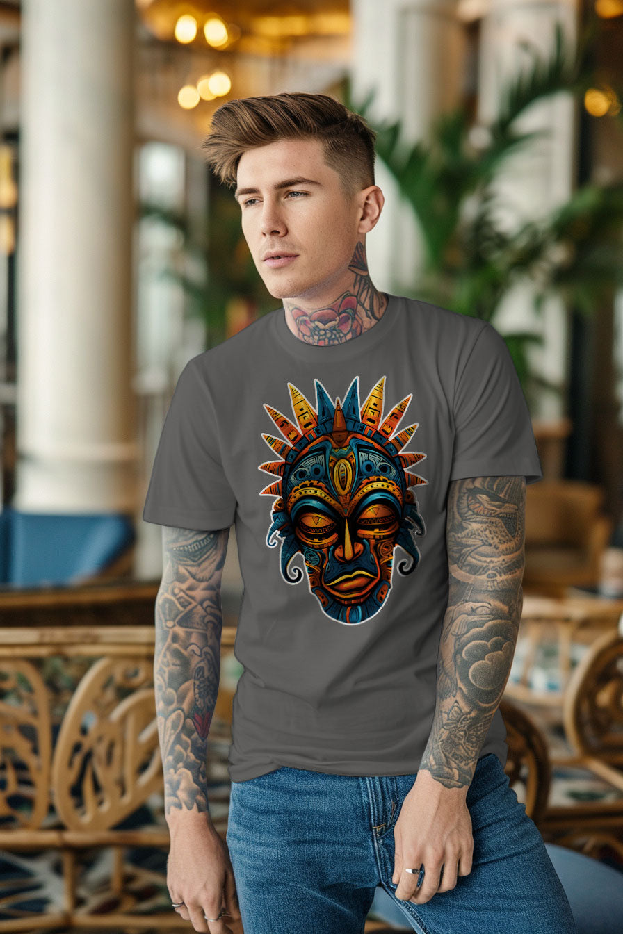 young tattooed man wearing a gray graphic t-shirt featuring a Aztec mask print