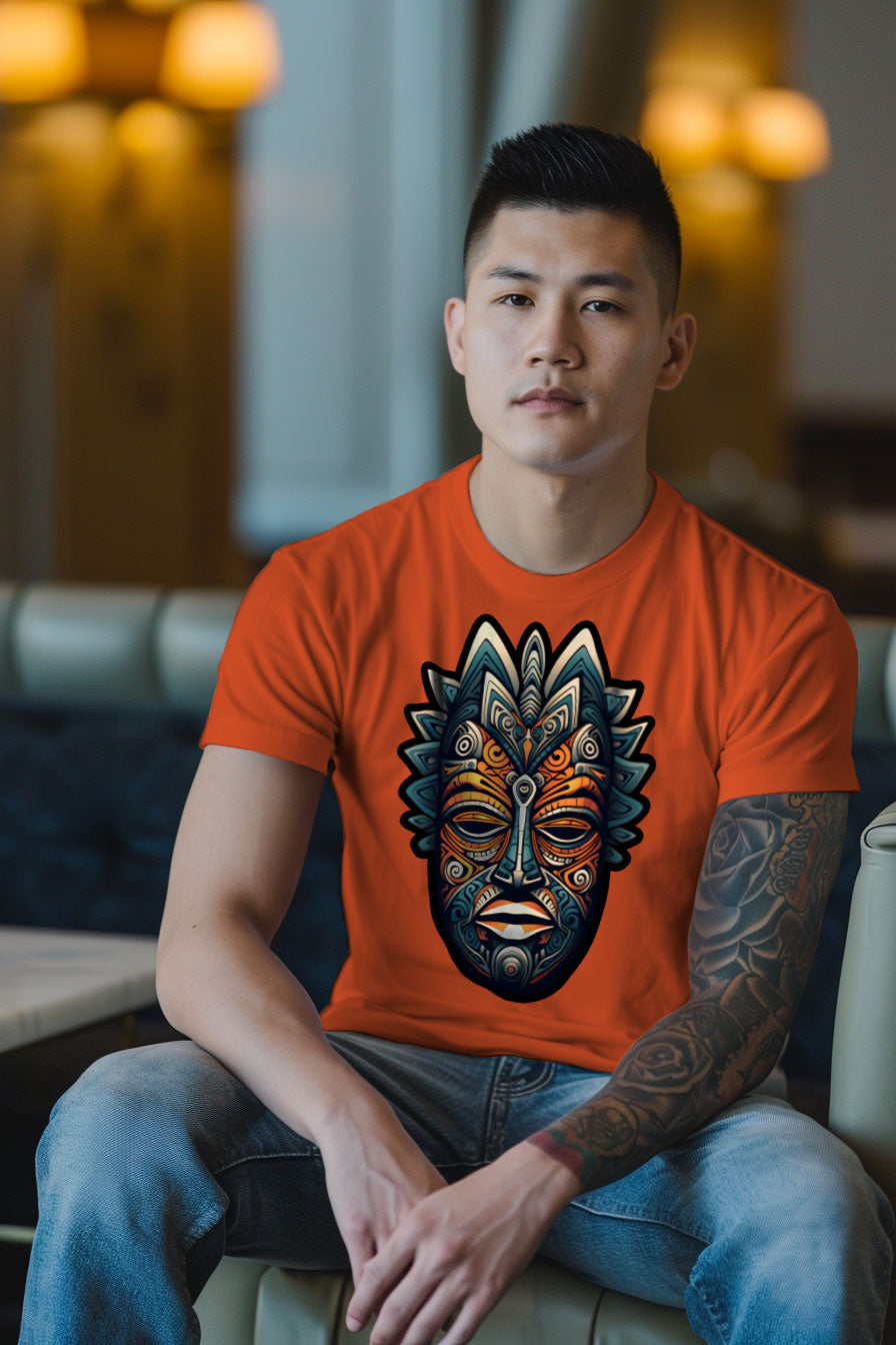 young tattooed man wearing a orange graphic t-shirt featuring an African mask print