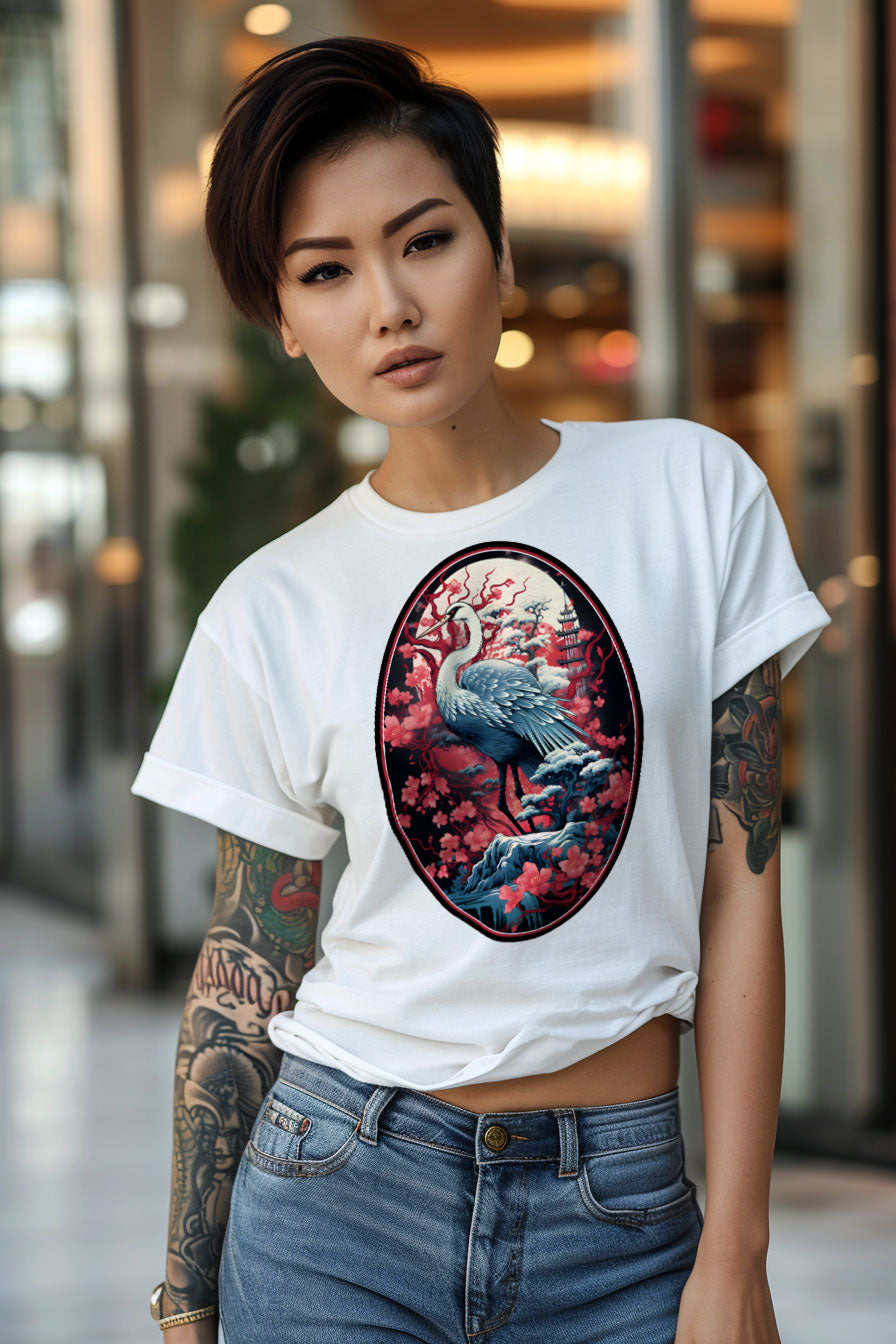 young tattooed woman wearing a white graphic t-shirt featuring a Crane with cherry blossom trees print